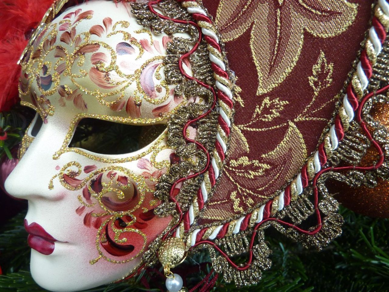 masque pour décoration avec un petit visage entouré par des plumes et du tissu, sur le front 2 bijoux