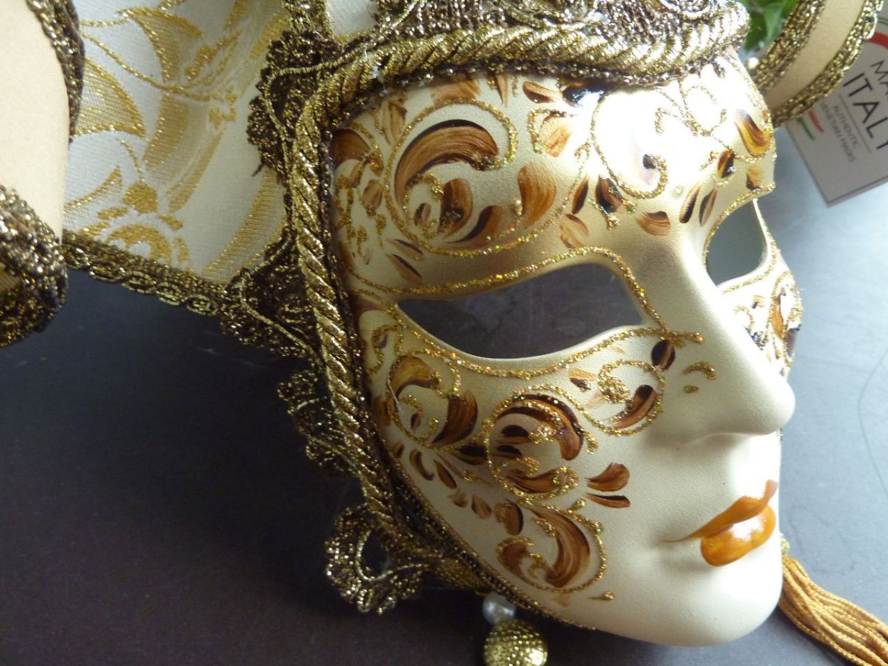 masque pour décoration avec tissu doré, visage avec dessin floreale sur fond blanc, gallon, pampilles , clochettes