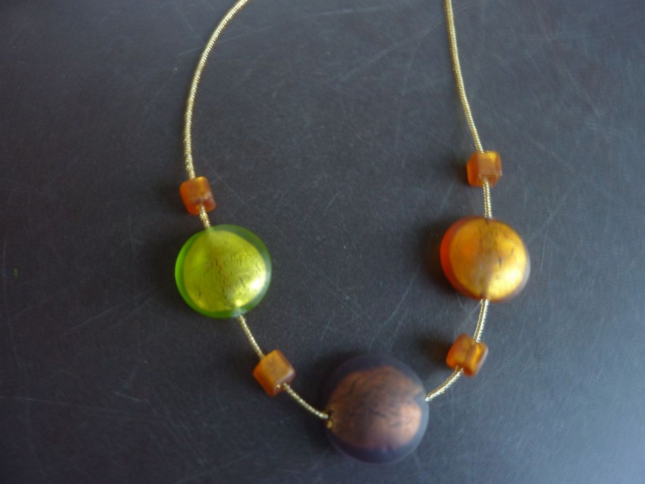 collier avec perles rocailles à la feuille d'or plus trois grandes perles rondes et plates. couleurs vert printemps , topaze, ametiste 