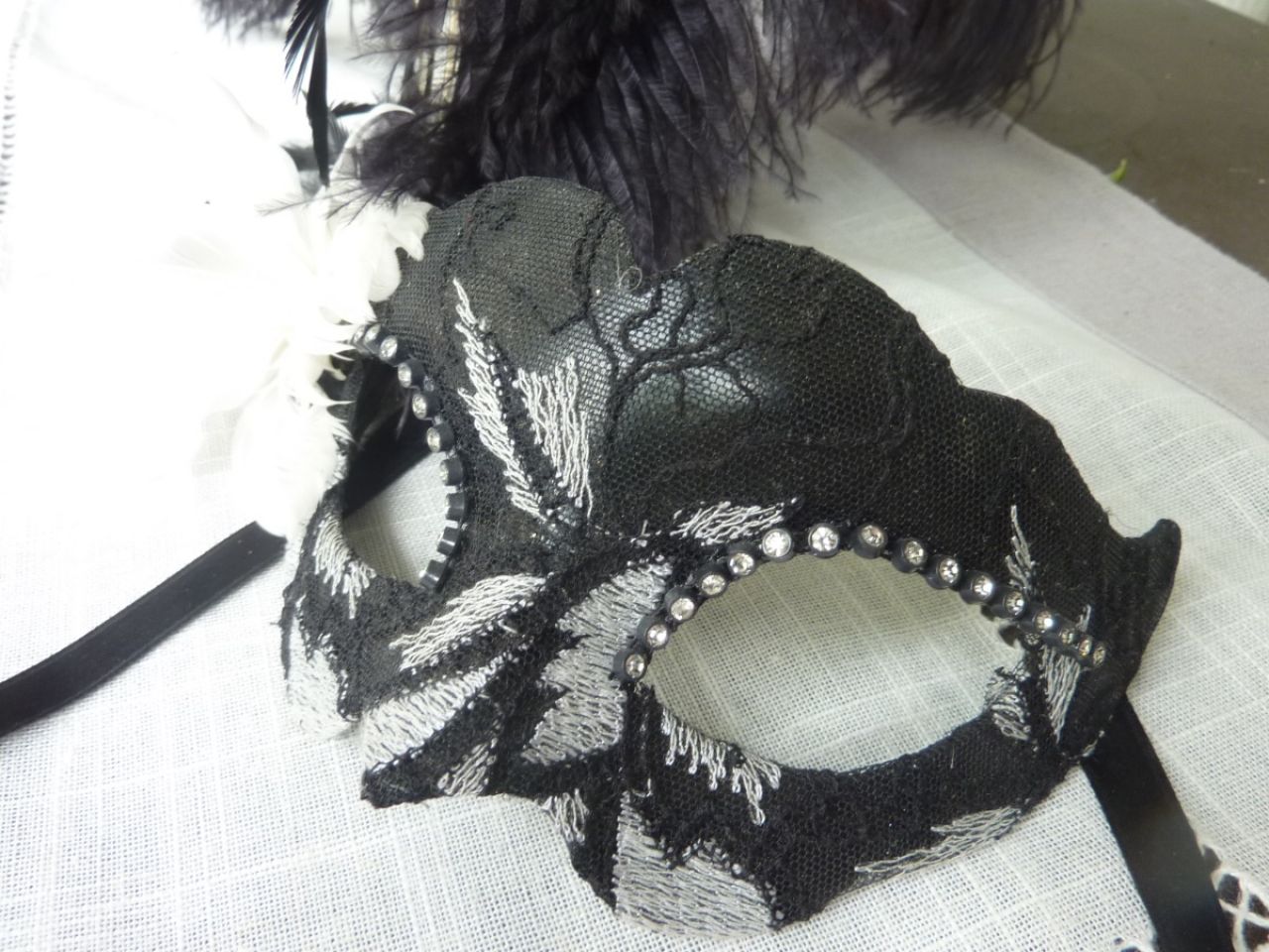 masque loup avec plumes d'autruche recouvert de tissu brodé , strass, couleur blanc et noir 