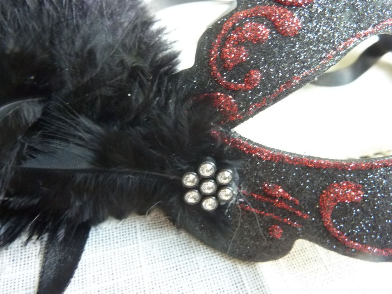 masque loup noir et rouge, plumes d'autruche noir, petit bijoux en strass, paillettes et glitter, décoré à la mai 