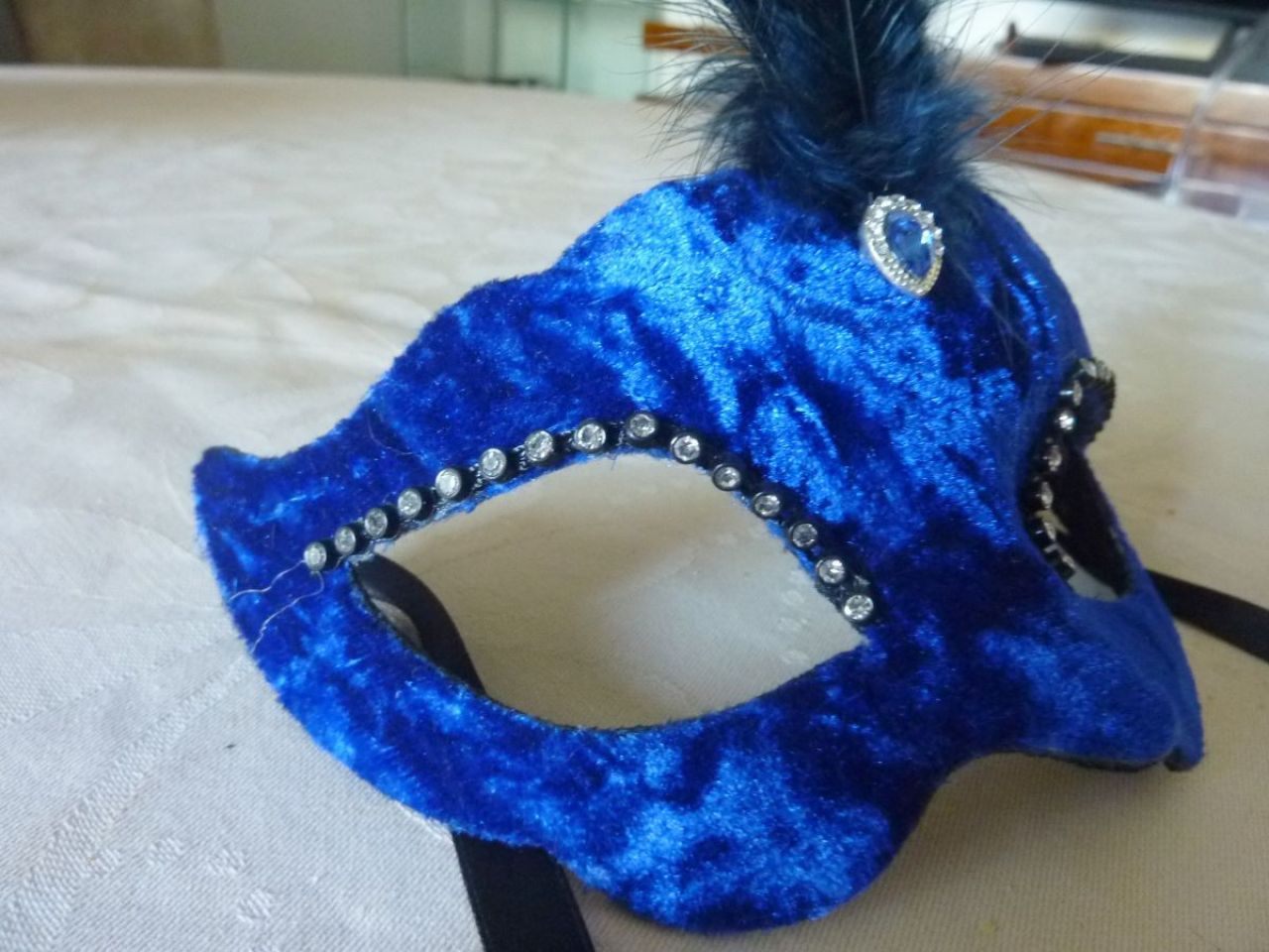 masque loup en velours bleu, petites plumes centrales avec bijoux, strass autour des yeux , très léger et facile à porter  