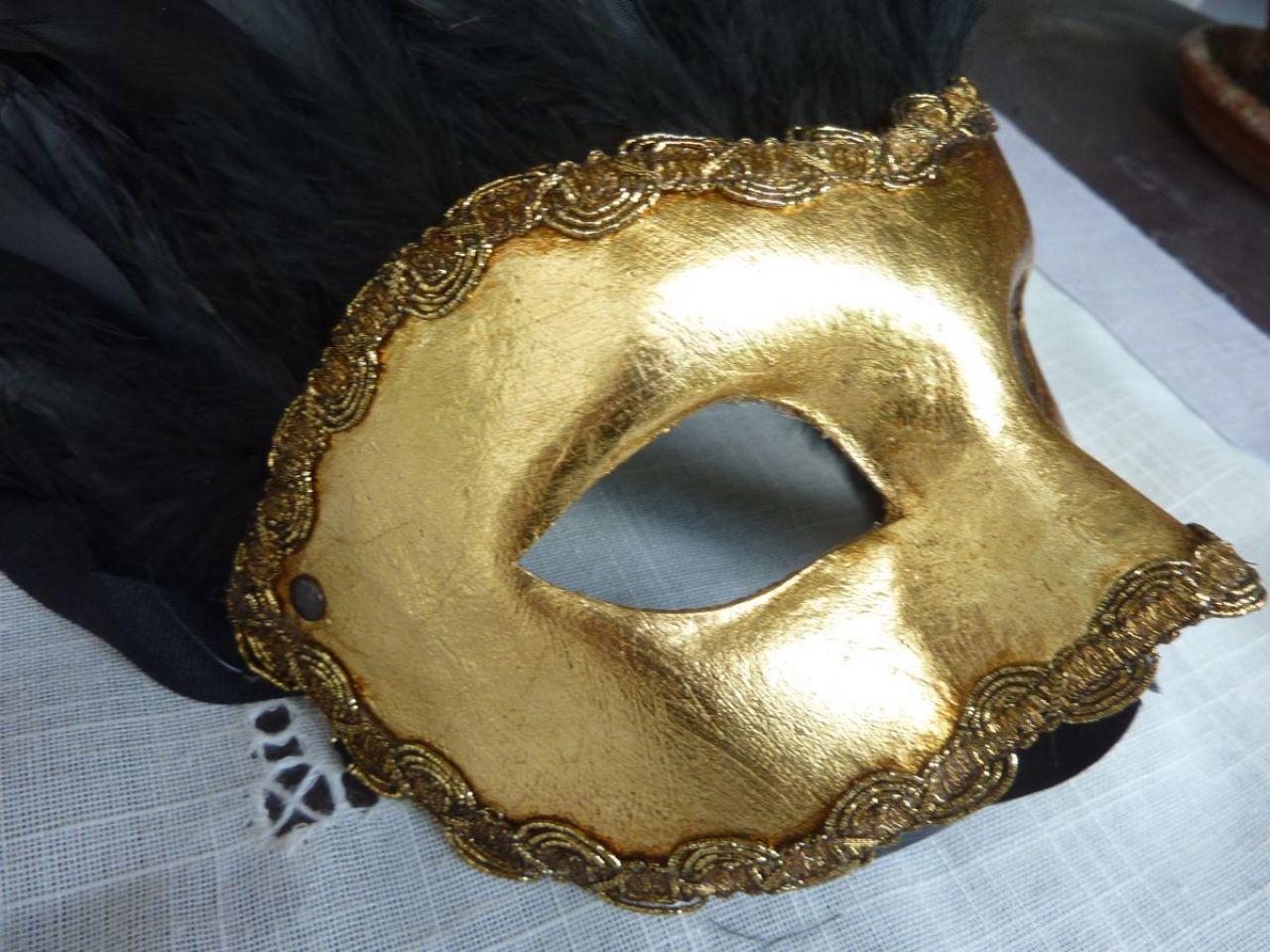 masque loup en papier mâché recouvert de feuille d’or, gallon doré, plumes noir