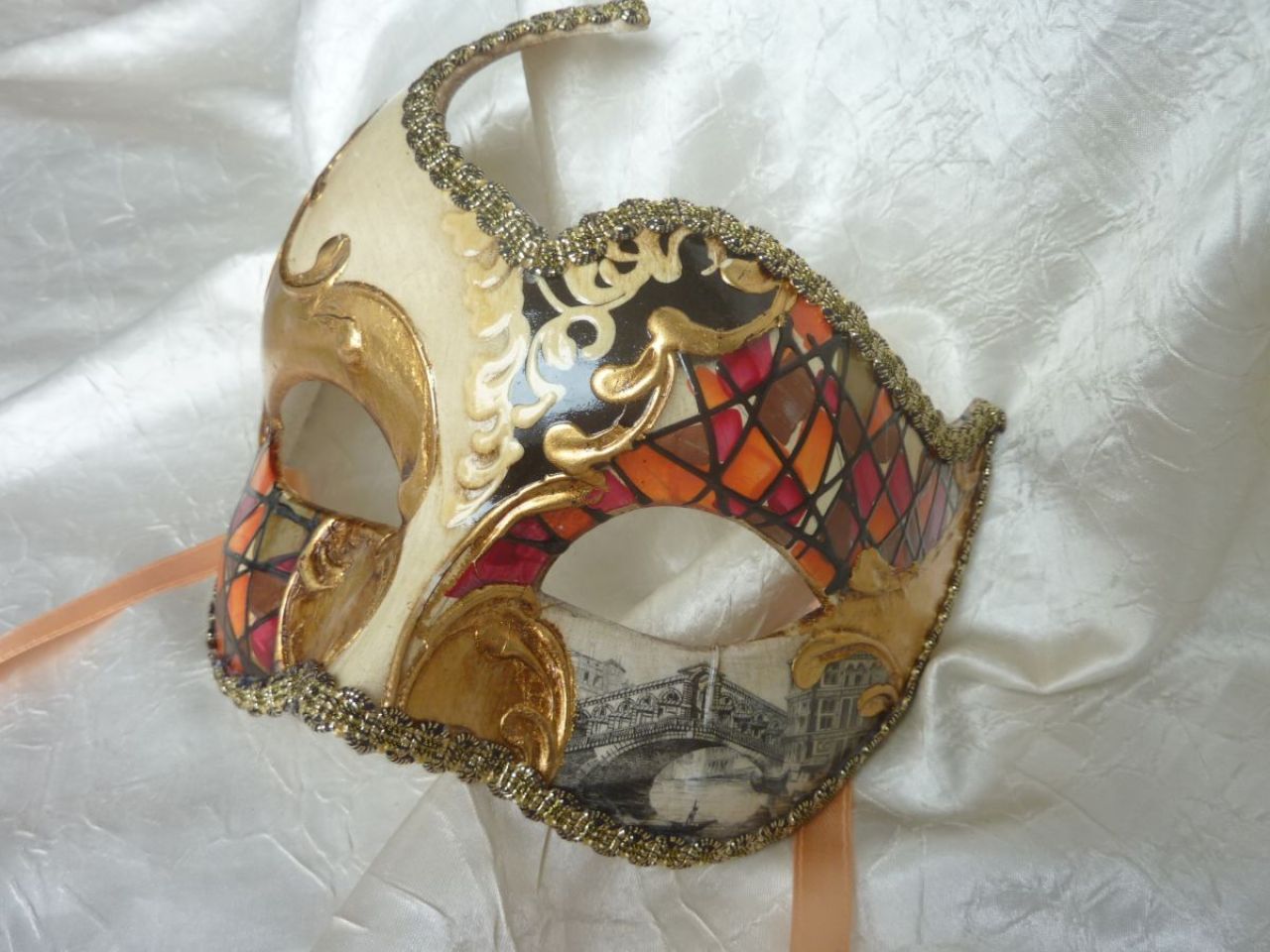 masque loup avec décoration rouge et orange, fond blanc avec feuille d'or, reproduction d'une vue du pont de Rialto 