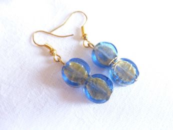 Boucles avec 2 perles en verre de Murano. Cristal bleu sur fond doré, couleur bleu transparent