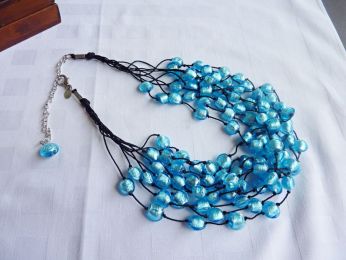 magnifique collier composé de 9 fils en soie noir sur les quels sont disposées à intervalles réguliers de dizaines de perles couleur Aqua mare ; travail artisanal de Murano