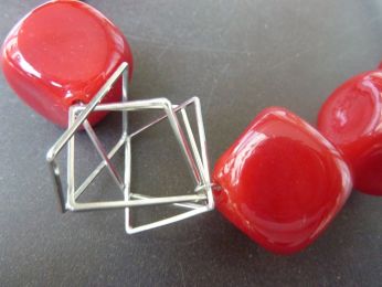 collier avec grandes perles rouges soufflées, élément geometric en acier , fil en gros caoutchouc