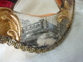 masque loup avec décoration rouge et orange, fond blanc avec feuille d'or, reproduction d'une vue du pont de Rialto 